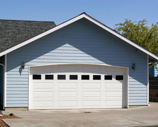 Light blue garage with a white garage door